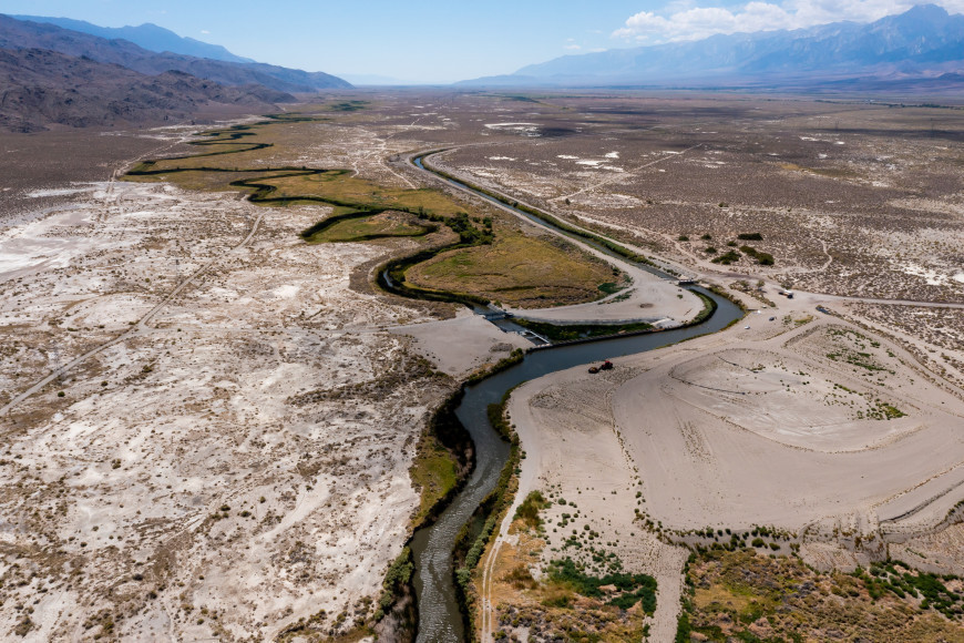 The Owens River flows south toward the headgates of the Los Angeles Aqueduct, which allows some water to travel downstream, left, and diverts the rest of the flow to service the massive municipality via the aqueduct, right, in Inyo County, California, on Wednesday, Aug. 10, 2022.