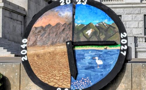 A large wooden clock depicting Great Salt Lake's demise was a central art piece at a rally Nov. 11, 2023. Aimee Van Tatenhove, UPR