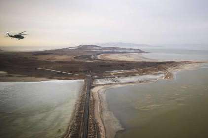A Blackhawk helicopter flies over the Great Salt Lake as Utah lawmakers take an aerial tour of the lake with the Utah Army National Guard on Feb. 15. Utah experts project the lake will fall another 2 feet below the record low set last year. (Scott G. Winterton)