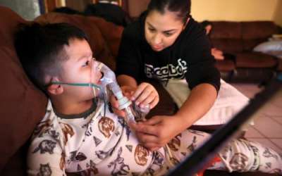 Rosa Mandujano reattaches part of her son Ruben Mandujano’s nebulizer after he pulled it off prematurely hoping he was done, at their home near the Salton Sea and Mecca, California, on Thursday, Dec. 14, 2023. Ruben, 5, has asthma and is autistic. He doesn’t like the nebulizer, which administers albuterol, as it often makes him throw up. Kristin Murphy, Deseret News.